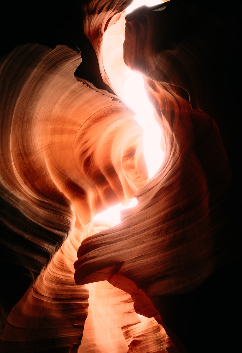 Light streams through a narrow sandstone canyon.